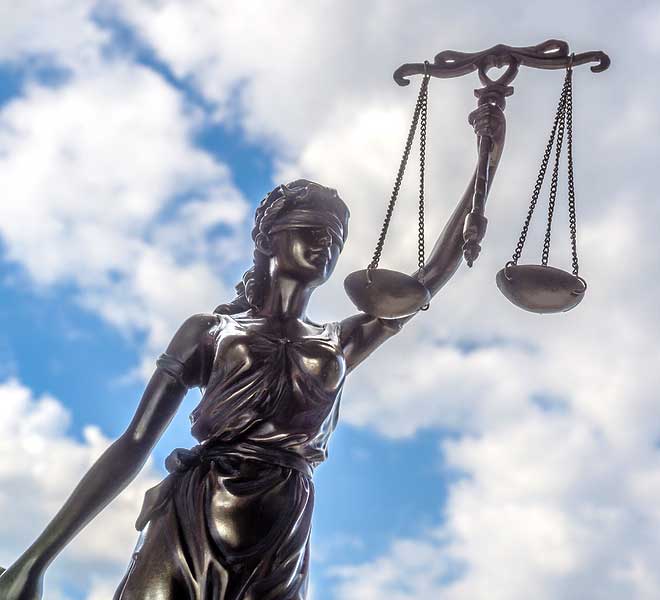 metal statue of Justice as a woman wearing a blindfold and holding up a set of evenly balanced scales